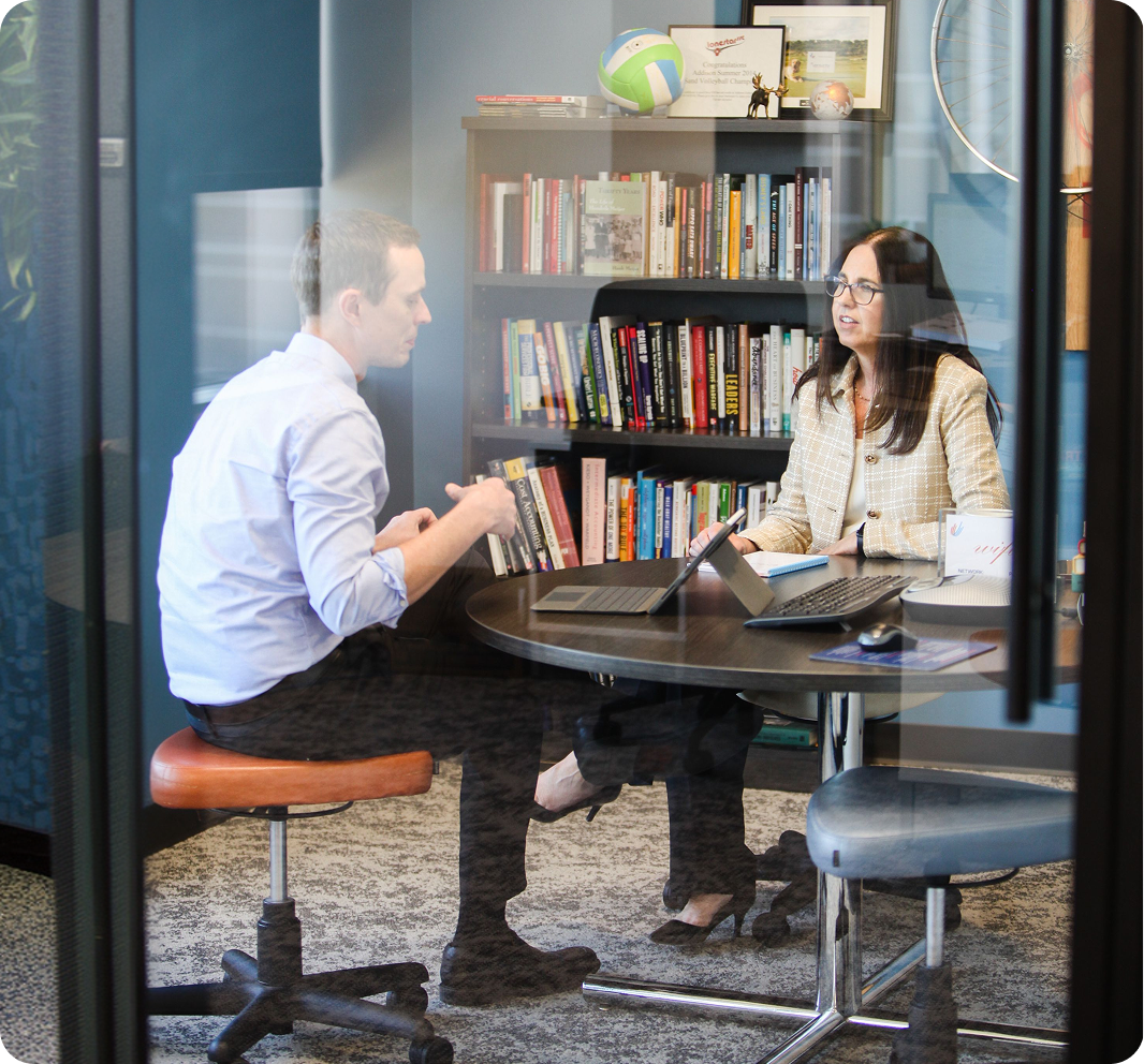 Two colleagues meeting at a table in a modern office